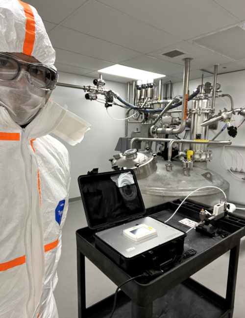 Technician in protective suit performing ISO 8573-1 compressed air quality analysis in a controlled environment
